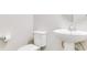 Simple and clean bathroom with pedestal sink and toilet at 11637 Meadow Grove Cir, Orlando, FL 32836