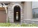 Elegant entryway with arched stone details and a glass front door at 11637 Meadow Grove Cir, Orlando, FL 32836