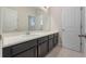 Bathroom with dark vanity, quartz countertop and large mirror at 14537 Golden Harbor Ln, Winter Garden, FL 34787