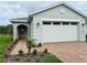 Newly constructed home with a two-car garage and landscaped walkway at 3185 Songbird Cir, Harmony, FL 34773