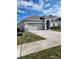 Single-story home with a two-car garage and landscaping at 3509 Yarian Dr, Haines City, FL 33844