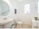 Clean bathroom with pedestal sink and round mirror at 664 Benoi Dr, Davenport, FL 33896