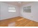 Simple bedroom with light wood floors and two windows at 6928 Sugarbush Dr, Orlando, FL 32819