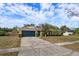 One-story house featuring a stone exterior, dark garage door, and neat landscaping at 6928 Sugarbush Dr, Orlando, FL 32819