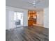 Open living room with grey vinyl flooring, kitchen view, and access to lanai at 6928 Sugarbush Dr, Orlando, FL 32819