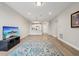 Spacious living area featuring hardwood floors, a large TV, and open floor plan at 7517 Laureate Blvd # 4205, Orlando, FL 32827