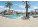 Relaxing community pool surrounded by palm trees at 7517 Laureate Blvd # 4205, Orlando, FL 32827