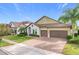 Two-story house with stone accents, tile roof, and a three-car garage at 8077 Chilton Dr, Orlando, FL 32836