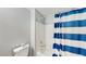 Simple bathroom with a tub and blue and white striped curtain at 923 Lake Berkley Dr, Kissimmee, FL 34746