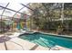 Inviting screened pool and spa with patio loungers and umbrella at 925 Balmoral Dr, Davenport, FL 33896