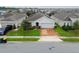 One-story house with solar panels, brick driveway, and grassy front yard at 975 Benjamin Trl, Davenport, FL 33837