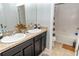 Double vanity bathroom with dark cabinets and a bathtub at 975 Benjamin Trl, Davenport, FL 33837
