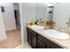 Double vanity bathroom with dark wood cabinets at 975 Benjamin Trl, Davenport, FL 33837