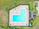 L-shaped community pool with surrounding patio and seating areas at 975 Benjamin Trl, Davenport, FL 33837