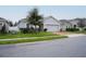 One-story house with gray exterior, red door, and brick driveway at 975 Benjamin Trl, Davenport, FL 33837