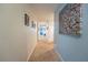 Long hallway with light walls and carpet, leading to living areas at 975 Benjamin Trl, Davenport, FL 33837