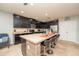 Kitchen island with seating, granite countertops, and dark wood cabinets at 975 Benjamin Trl, Davenport, FL 33837