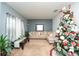 Cozy living room features a sectional sofa and Christmas tree at 975 Benjamin Trl, Davenport, FL 33837