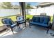 Relaxing screened porch with wicker furniture and blue cushions at 975 Benjamin Trl, Davenport, FL 33837