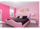Main bedroom with pink upholstered bed and modern art above the bed at 1550 Observer Ln, Davenport, FL 33896