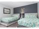 Twins bedroom with grey platform beds, and cheerful lemon-patterned bedding at 1550 Observer Ln, Davenport, FL 33896