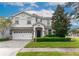 Two-story house with white and stone exterior, three-car garage, and landscaped lawn at 1550 Observer Ln, Davenport, FL 33896