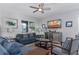Living room with blue couches, large TV, and patterned chairs at 1550 Observer Ln, Davenport, FL 33896
