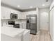 Modern kitchen with white cabinets, stainless steel appliances, and quartz countertops at 1912 Portcastle Cir, Winter Garden, FL 34787