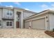 Modern house exterior with stone accents, three car garage, and paver driveway at 2205 Lake Sylvan Oaks Ct, Sanford, FL 32771