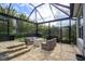 Screened patio with seating area and view of landscaping at 2205 Lake Sylvan Oaks Ct, Sanford, FL 32771