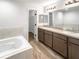Double vanity bathroom with soaking tub and walk-in closet at 225 Arbuthnot St, Winter Haven, FL 33881