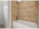 White bathtub with tan tile surround at 2806 Balforn Tower Way, Winter Garden, FL 34787
