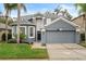 Two-story house with gray exterior, landscaping, and a two-car garage at 2806 Balforn Tower Way, Winter Garden, FL 34787