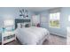 Light blue bedroom with a queen bed, window, and artwork at 303 River Front Way, Edgewater, FL 32141