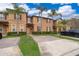 Tan two-story townhome with palm trees and brick driveway at 3030 Calabria Ave, Davenport, FL 33897