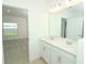 Double vanity bathroom with white cabinets and a large mirror at 329 River Front Way, Edgewater, FL 32141