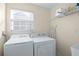 Laundry room with washer, dryer, and shelving for storage at 3809 Sun Dew Dr, Orlando, FL 32828