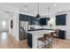 Modern kitchen with navy blue cabinets, white quartz countertops, and stainless steel appliances at 4023 Meandering Bay Dr, Apopka, FL 32712