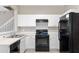 Modern kitchen with white cabinets, black appliances, and ample counter space at 6292 Twain St # 101, Orlando, FL 32835