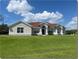 Single-story home with red tile roof and large green lawn at 14770 Bicky Rd, Orlando, FL 32824