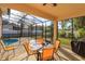 Relaxing screened patio with table and chairs, overlooking the pool at 15423 Markham Dr, Clermont, FL 34714