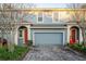 Two-story townhome with gray exterior, red door, and paver driveway at 309 Coral Beach Cir, Casselberry, FL 32707