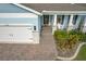 Light blue house exterior with white garage door, brick walkway, and landscaping at 3288 Sailing Pier Ave, Winter Garden, FL 34787