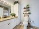 Clean bathroom with granite countertops, white cabinets, and decorative shelving at 5269 Wellington Park Cir # 23, Orlando, FL 32839