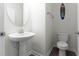 Small bathroom with pedestal sink, toilet, and oval mirror at 12128 Illustration Dr, Orlando, FL 32832