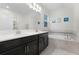 Bathroom with double vanity, soaking tub, and an enclosed shower at 12128 Illustration Dr, Orlando, FL 32832