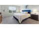 Bedroom with a blue upholstered bed, carpeted floor, and window with blinds at 12128 Illustration Dr, Orlando, FL 32832