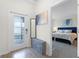Bright entryway with bench, mirror and view into a bedroom with blue headboard at 12128 Illustration Dr, Orlando, FL 32832