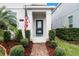 Front entry with brick walkway, American flag, and lush landscaping at 12128 Illustration Dr, Orlando, FL 32832