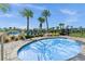 Relaxing hot tub surrounded by palm trees and lounge chairs at 12128 Illustration Dr, Orlando, FL 32832